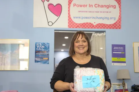 Woman holds a pack of diapers